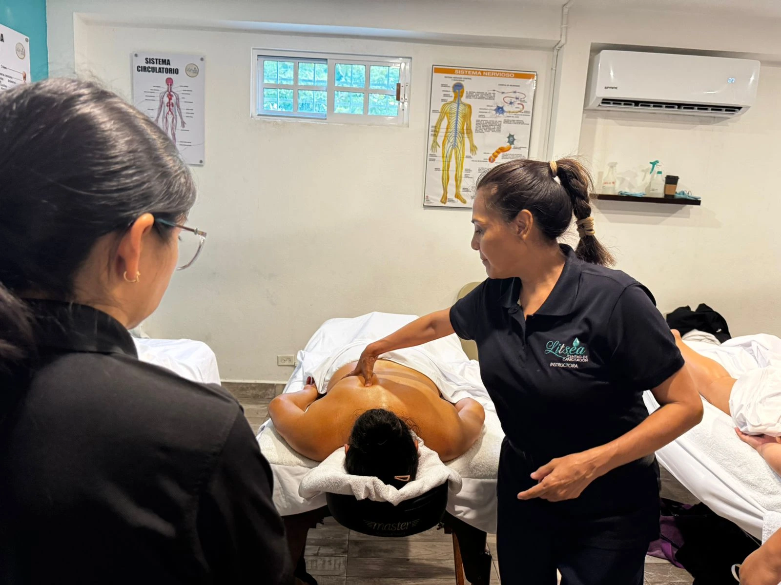 Práctica de masaje corporal en un aula de masoterapia de Litsea